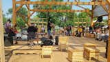 A four-piece band plays in the Thought Barn for community members on the weekend. The timber structure and wooden, slatted stools were all made by students and faculty of the apprenticeship program.&nbsp;