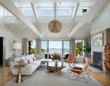 At the heart of the home is a bright family room offering unobstructed water views through a large sliding door and picture windows. Clerestory windows illuminate the beamed ceiling.  Photo 4 of 8 in This Seaside Home Offers Comfort and Views for Today’s Modern Family