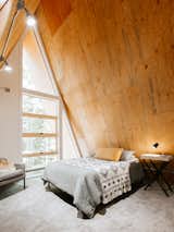 The second bedroom is located beneath the A-frame’s apex.. With floor-to-ceiling windows, the nook is a cozy yet bright place to start and end each day.