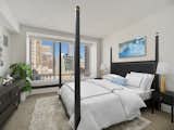 The bedroom is also spacious and full of natural light, thanks to another large window overlooking the downtown skyline.