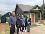 The Pivot team poses in front of a pair of tiny homes at the 12-acre tiny home community. From left to right: Terry Clinefelter, Marcus Ude, Melanie Anthony, Stephon Smith, and Richard McKown.