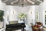 Musically inspired spaces throughout the home pay homage to the professions of its former and current owners. Here, a small pavilion off of the living room holds a baby grand piano and opens to a large deck.