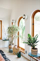 Wood-framed arched windows line the living spaces, bringing gorgeous garden views inside.