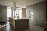 In the kitchen, the cabinets are by Henrybuilt, the countertop is by Caesarstone, and the range hood is from Futuro.