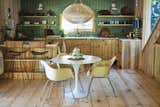 In the kitchen, a Saarinen table from Design Within Reach and a trio of Eames Zenith Lounge chairs pop against the knotty cedar cabinetry and wide-plank pine floors.
