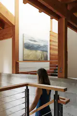 The concrete wall next to the stairs is part of the house’s foundation. “The idea was to use as much of the structure as finish material as possible,” says Sherry. A painting by Thea Schrack hangs nearby.