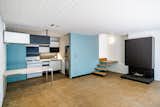 Inside the first of two smaller units, bright blue cabinets contrast with the white-painted brick and wood ceilings. The original fireplace serves as the main focal point in each of the apartments.