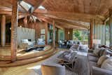 The elegant living room features multiple seating areas. Original timber poles provide structural support, while lighter hardwood floors help to reflect the natural light and brighten the space.