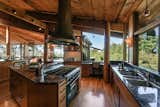The original hand-hammered copper hood hangs over a large central island. Renovations helped to modernize the kitchen with new cabinetry, high-end appliances, and granite countertops.  Photo 5 of 14 in A Berkeley Home Designed by Two Frank Lloyd Wright Protégés Seeks $2.65M