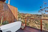 The sheltered deck off the master suite includes a 70-inch soaking tub. Distant views from the bath include downtown Los Angeles and the&nbsp;Griffith Park Observatory.
