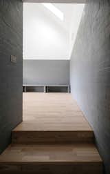 Concrete blocks form the walls inside and out. Here, in a hallway leading to one of the living areas, they echo the gray color of the zinc roofing.
