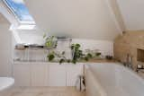 Bath Room and Drop In Tub Another skylight can be found in the master bathroom. The cozy space features a soaking tub and custom cabinetry built into the eaves.  Photos from This Darling Converted Barn in an English Village Seeks £980K