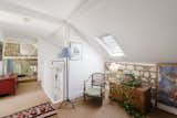 Upstairs, a cozy reading area is nestled within an alcove in the loft space.