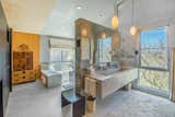 The bright master bath includes a large marble vanity and a six-person tub in the back.