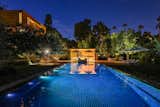 Outdoor, Trees, Back Yard, Shrubs, and Large Pools, Tubs, Shower The pool house gleaming with light at night.  Photo 1 of 100 in Favorites by George Humann