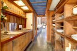 At one end of the space, a galley-style kitchen offers redwood cabinetry and shelving. The mostly original space has been upgraded with granite countertops and some new fixtures.