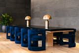 Deep blue velvet chairs, brass lamps, and polished concrete add decadence that's characteristic of both Industrious and Equinox.