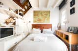 Unwind on the balcony of a 130-year-old building in the heart of the Barcelona's oldest district. Enjoy open-plan, loft-style living with neutral decor, open shelving, and rustic, exposed-beam ceilings.   Photo 3 of 16 in 16 Places to Stay in Barcelona for Less Than $100 a Night