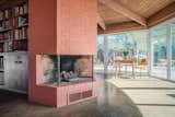 An original three-sided fireplace centers the living area.  Photo 8 of 16 in This Rare Midcentury Home Will Be Preserved Forever—and Now You Can Spend the Night