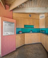Teal, muted red brick, and aged, wooden cabinetry meet in the kitchen.  Photo 9 of 16 in This Rare Midcentury Home Will Be Preserved Forever—and Now You Can Spend the Night
