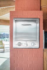 A brick wall near the kitchen counter features a true period piece: an original Thermador oven.