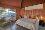 A look at one of the home’s other bedrooms, which is clad almost entirely in wood paneling.