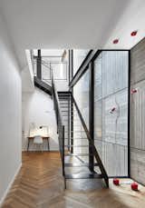 Herringbone floors and a board-formed concrete wall create a linear motif in the second-floor stairwell.