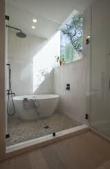 In the rear corner of the master bathroom is an enclosed water closet that is drenched in natural light from a picture window. A soaking tub is set beside the rain shower.&nbsp;