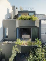 At the rear of the house, sculptural terraces are softened by plantings designed by Delphine Huetz. The sliding glass doors are by Fleetwood and the Carbon counter stools on the roof deck are by Bertjan Pot for Moooi.