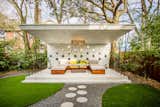 A concrete cabana is tucked away in the backyard, complete with custom furniture and lighting—both designed by Karen. The metal light fixture was fabricated by local artist Eric Doran, who also designed other metalworks on the property.