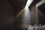 Light penetrates the concrete bathroom via a skylight.