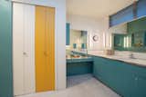 The ensuite bathroom features a playful color scheme, with a large closet and ample cabinetry for storage.