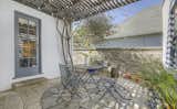 Outside, a trellis covers the stone patio, creating a tranquil space for outdoor dining.