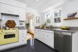 In addition to new countertops and fixtures, the updated kitchen features plenty of cabinet space. A vintage oven adds a playful pop of color.