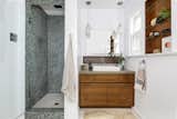 The renovated bathroom features a mosaic-tiled shower, updated cabinetry, and built-ins.&nbsp;