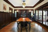 The room features a wall of doors opening onto the front porch, as well as additional built-ins.  Photo 13 of 17 in A Historic Craftsman Compound in L.A. Lists for $2.5M