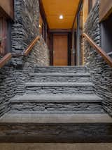 A stone-walled hallway leads to the main living area with walls of glass.  Photo 2 of 8 in A Midcentury Retreat by Architect and Usonia Founder Aaron Resnick Lists for $999K