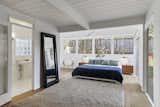 The light-flooded master bedroom feature a line of windows along one wall and sliding glass doors along another.