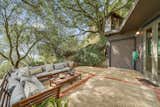 The spacious patio is shaded by several large, legacy live oak trees. Overlooking the area is The Nest, a detached writing and guest studio designed by architect and owner Jim Orjala.