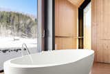 The soaking tub overlooks picturesque views of the property through a sliding glass door.