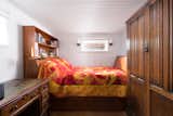 In total, the houseboat features two bedrooms. Here, the master bedroom is illuminated by several windows along the sides.