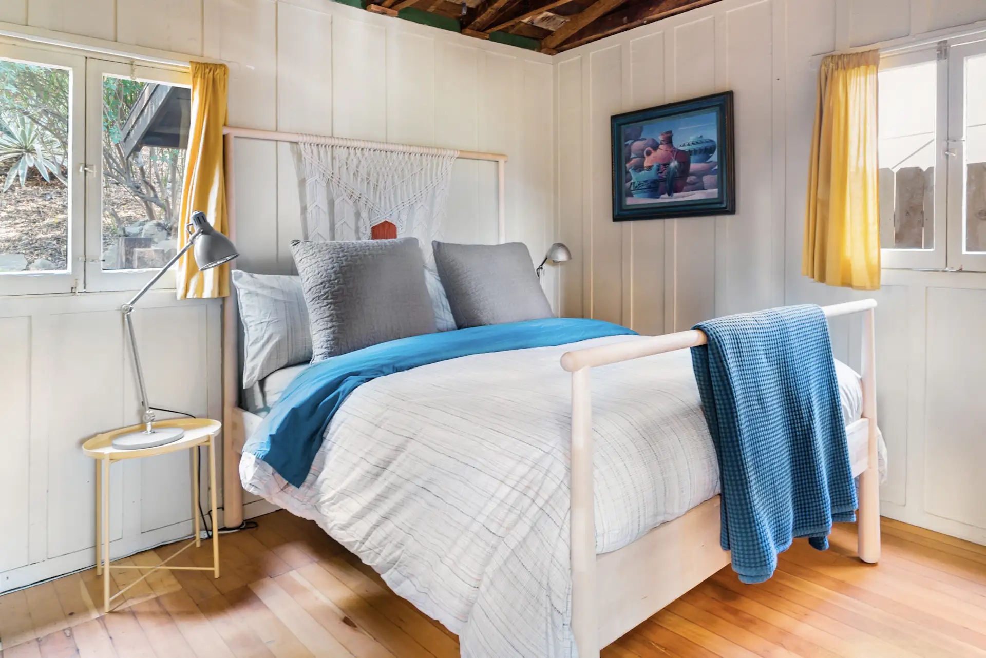 The light-filled bedroom in this cottage also features batten-and-board siding.