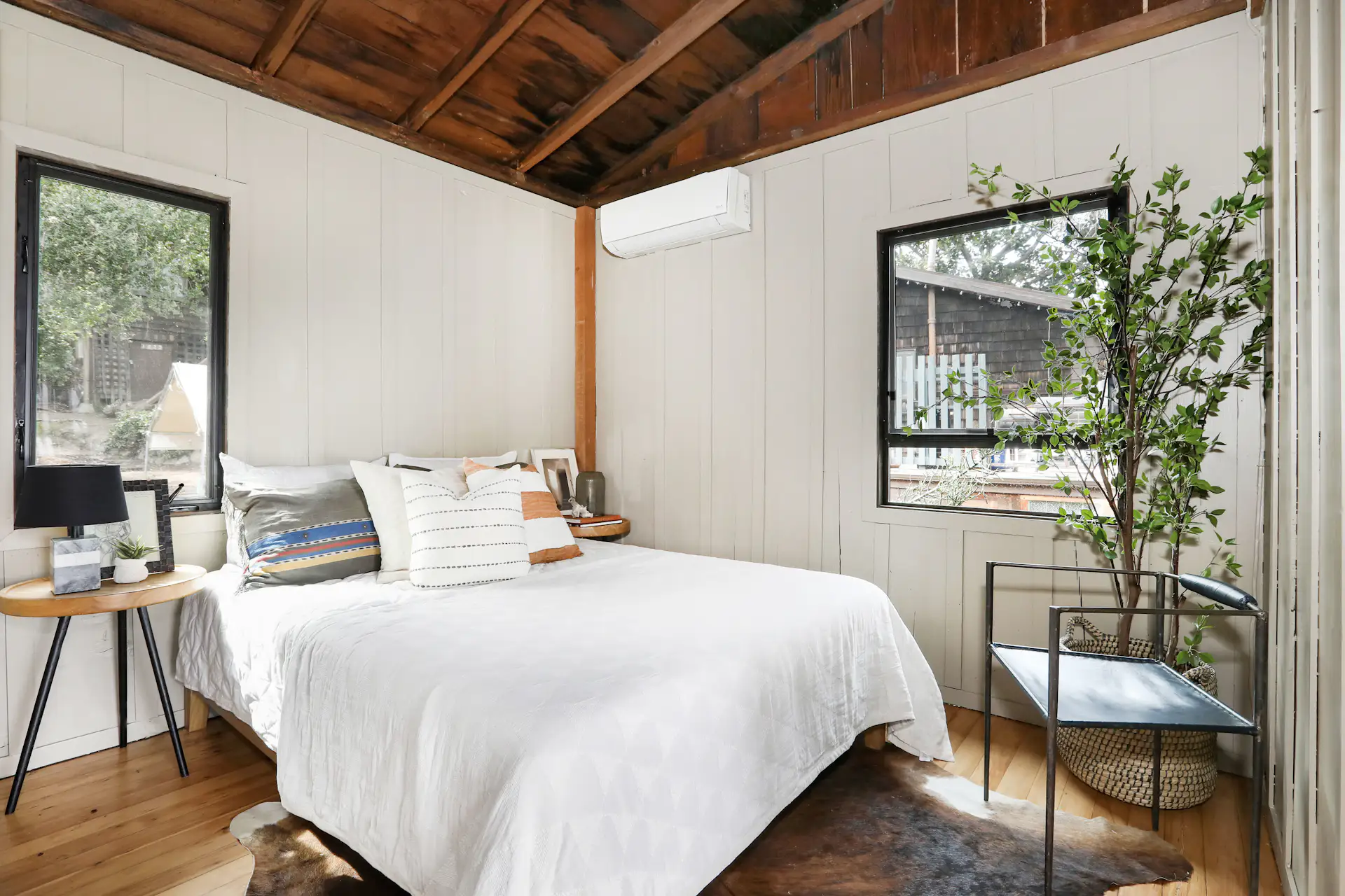 Exposed rafters continue into the bedroom, which also features batten-and-board siding.