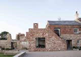 The disorderly nature of the ruin is juxtaposed against the modern extension and Victorian-era residence. The facade brickwork was largely completed using reclaimed materials, allowing the new section to sensitively blend into its surroundings.