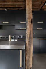 An original timber post stands beside the new sleek cabinetry and stainless-steel countertops.&nbsp;&nbsp;