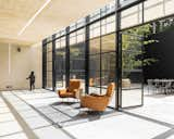 Steel-and-glass doors open up onto the rear courtyard patio. The two-story wall of glass dramatically illuminates the interior space.