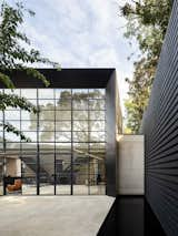 Outside, large retaining walls bound the rear courtyard on three sides. A reflecting pool runs around the perimeter of the patio.