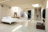 Upstairs, the master bedroom is encased in a concrete box, illuminated largely by natural light from several skylights placed around the room.