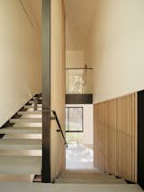The architects used cedar slats to enclose a steel-and-concrete staircase that leads to the master bedroom upstairs.