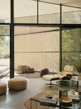 A large slider opens onto a small courtyard and the outdoors. The lounge chairs and ottoman are by Charles and Ray Eames for Herman Miller and the Rivet side table is from Frama.